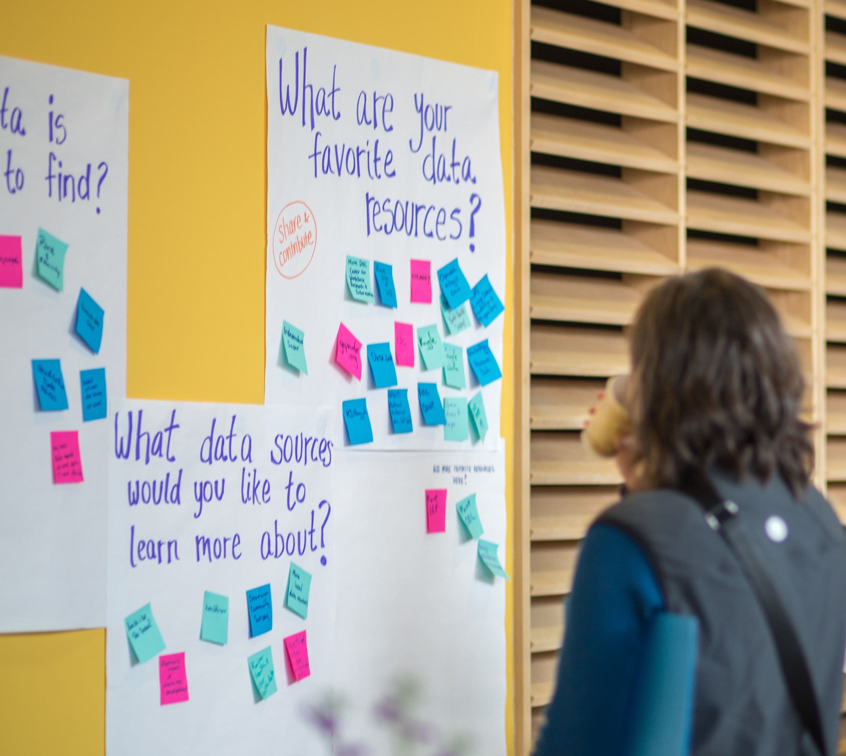 A person looks at posters on a wall about data resources